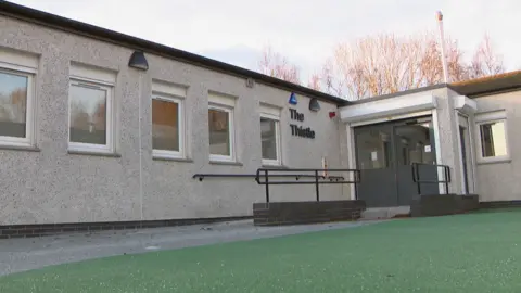 A grey, one-storey building with a flat roof.