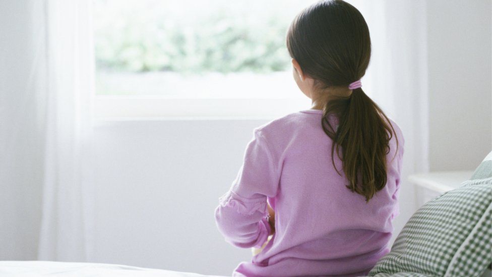 Girl looking out of bedroom window