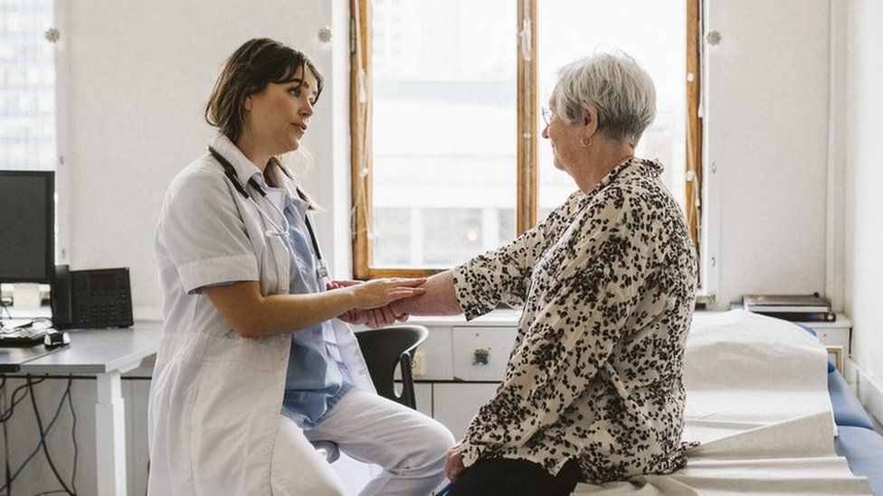 Stock shot of female doctor checking pulse of patient