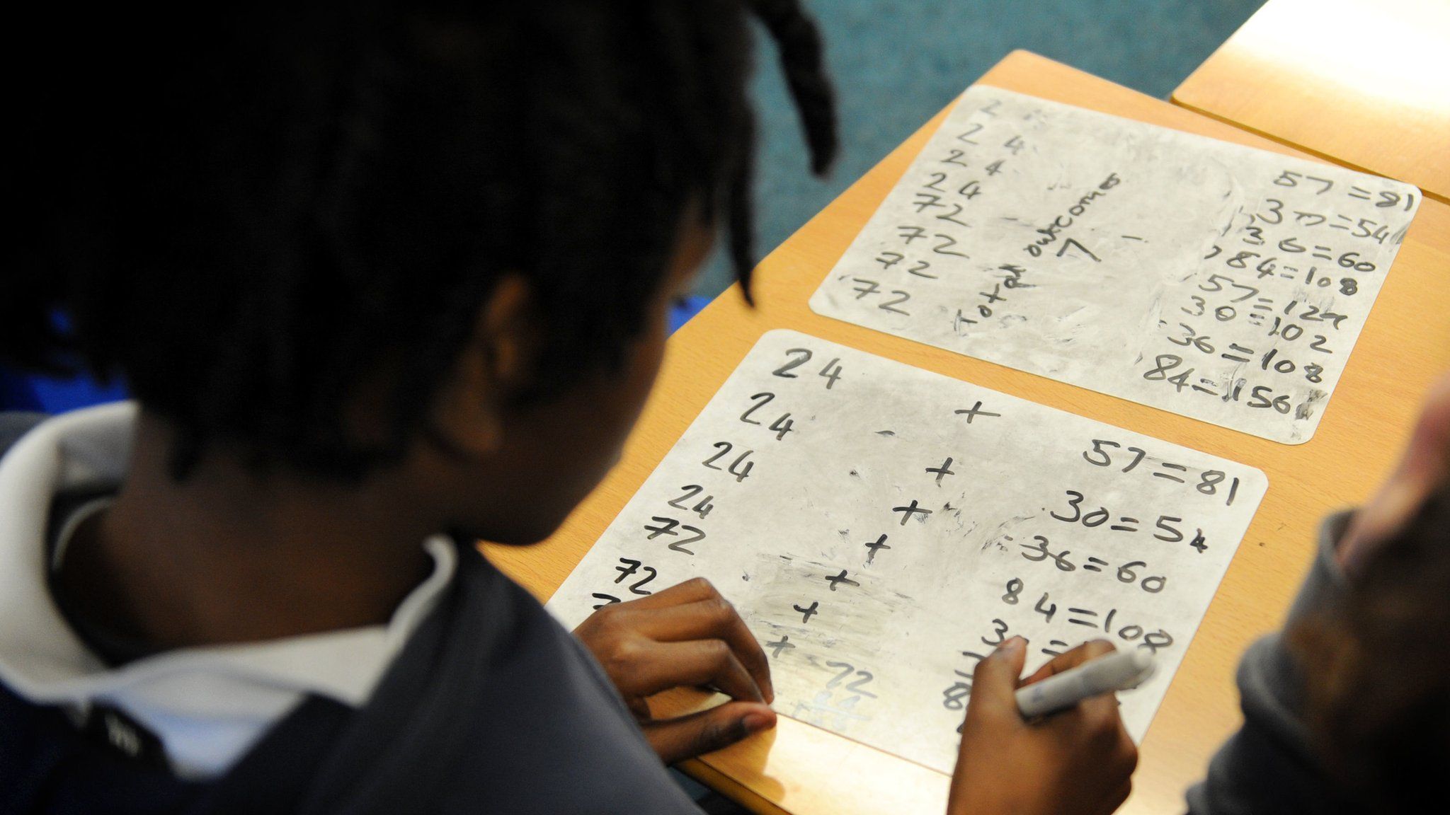 A young school child doing sums