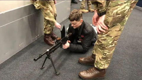 Jo Wilson Carys lying on the floor holding a gun