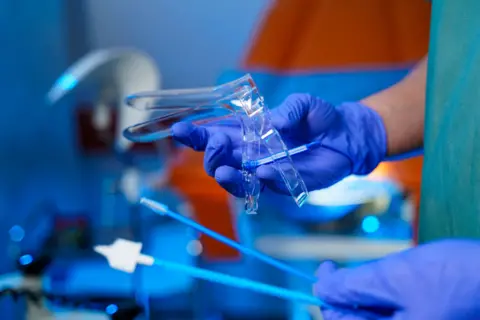 Getty Medic holds a speculum used in a smear test 