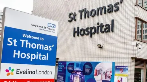 The outside of St Thomas' Hospital with the signage Welcome to St Thomas' Hospital outside the white brick or white tiled building.