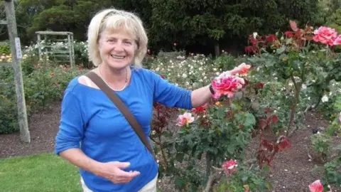 Matthew Carr-Gomm Danielle Carr-Gomm in blue top standing near rose garden.