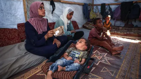 AFP Picture of a young boy who contracted polio, alongside his family 