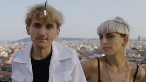 First Born Films Neil Harbisson in a white shirt and Moon Ribas in a black vest top, on a Barcelona rooftop