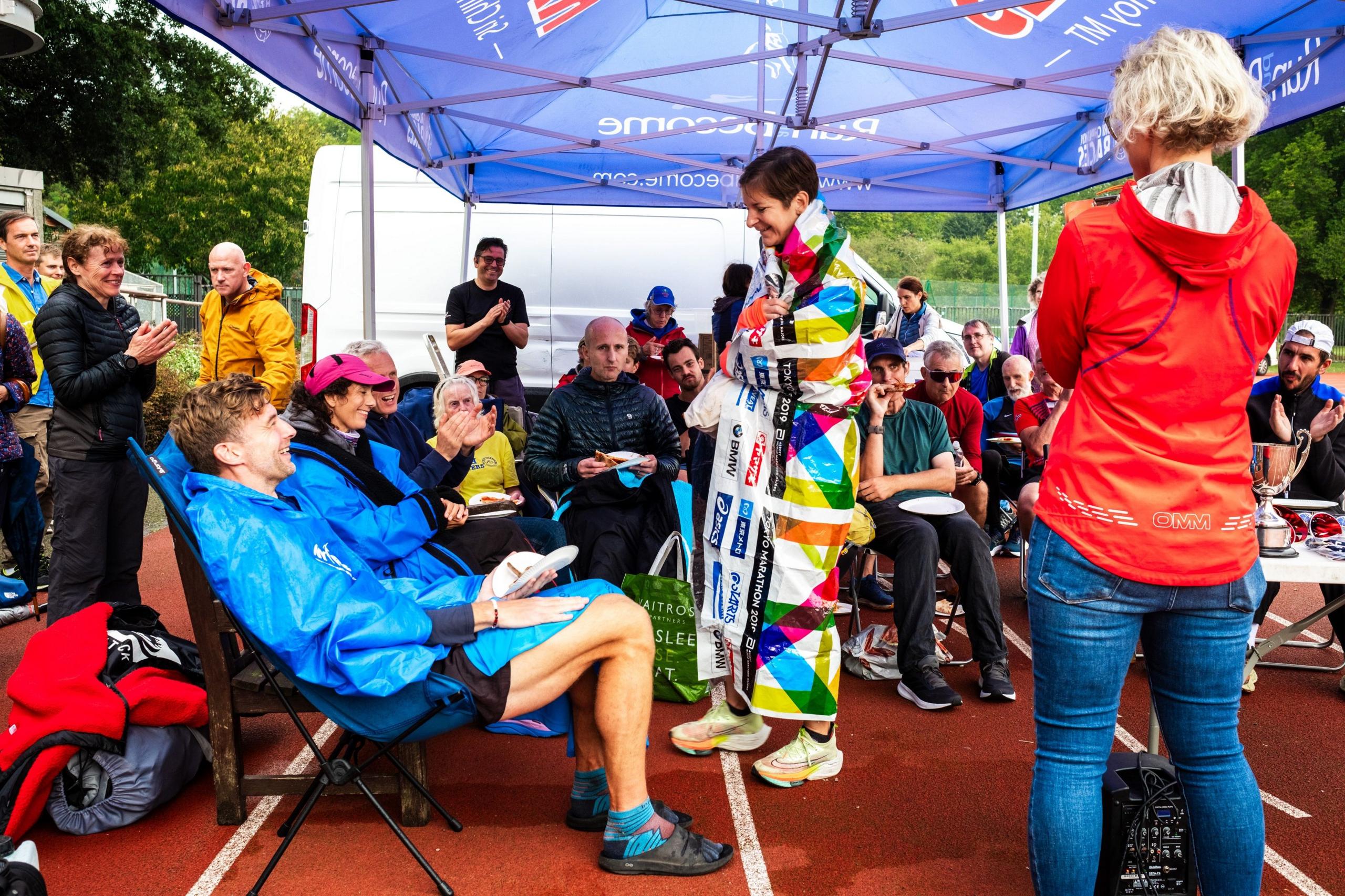 Sarah Funberburk, wrapped in a survival blanket, at the presentation ceremony for the Sri Chinmoy 24hr Track Race in Battersea