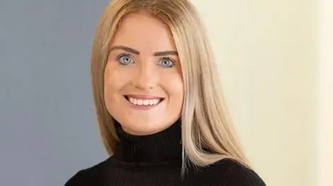 Squire Patton Boggs A formal picture of Simone White, who has blonde hair and blue eyes and is wearing a black top