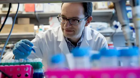 Memorial Sloan Kettering Cancer Center Dr Daniel Heller looks at small test tube 