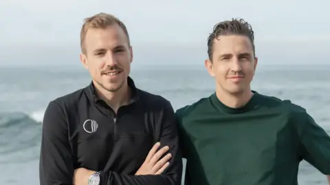 Corti Corti co-founders Lars Maaloe (left) and Andreas Cleve stand together with the sea behind them.