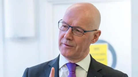 PA Media John Swinney head and shoulders shot wearing a suit and tie