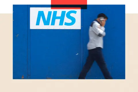 AFP/ Getty Images A man walks past an NHS signage 