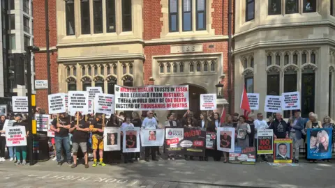 PA Bereaved families and friends stand in solidarity outside Arundel House in London where the Lampard Inquiry is taking place. They are all holding posters and placards of their loved ones or slogans representing why they want justice. One reads 'if mental health trusts in Essex had learned from mistakes there would only be one death instead of thousands of deaths'.