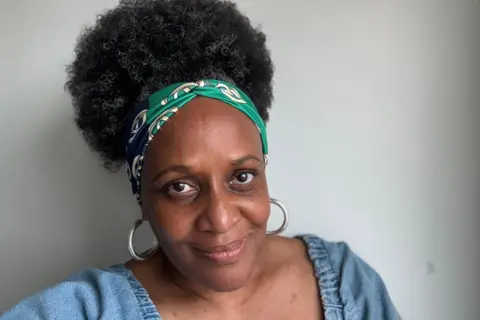 Venessa Swaby smiling against a grey backdrop