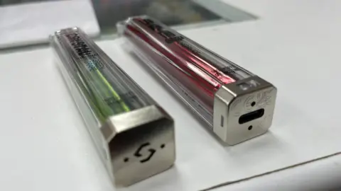 Ruth Clegg Two vapes next to each other, one is disposable and the other is a rechargeable vape with a charging point at the bottom