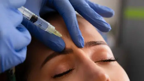 Getty Images A woman has a substance injected between her eyebrows