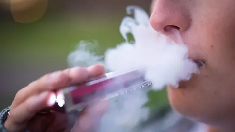 Getty Images A person holds a vape up to their mouth