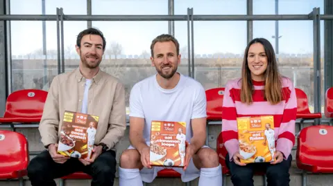 3 Bears Harry Kane holds a box of 3Bears cereal sitting between 3 Bears' founders