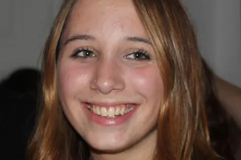 Figueiredo family Alice Figueiredo, a young woman with auburn hair, smiling. 