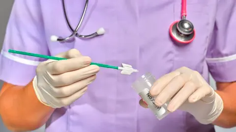 Getty Images Picture of a nurse holding a cervical screening test
