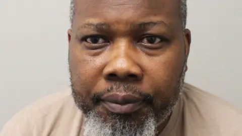 Met Police Benjamin Aninakwa mugshot - he faces the camera and is wearing a beige top