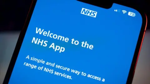 Getty Images Close up phone screen, with Welcome to the NHS App in white on a blue background.  