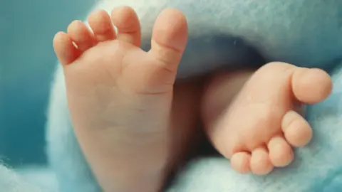 Getty Images Close up of baby's feet on a blue blanket 