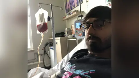 Supplied Raj having his life saving transplant at the Leicester Royal Infirmary in 2020 You can see a bag of stem cells being infused into his blood stream. Raj is lying on his hospital bed at the Leicester Royal Infirmary