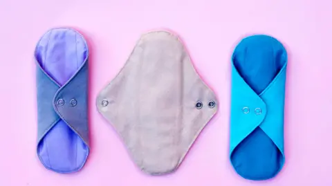 Getty Images Three reusable period pads on a pink background 