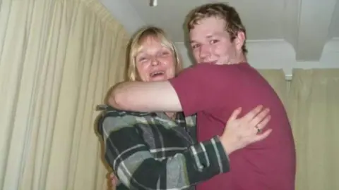 Family handout Hilary hugs her son Ben. They are both smiling.