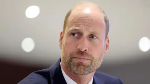 Reuters Close up shot of Prince William  in a navy suit 