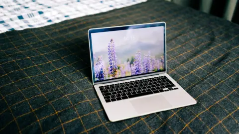 Getty Images Laptop showing nature wallpaper on bed
