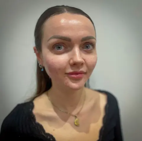 BBC Abby has long brown hair and she is looking straight at the camera