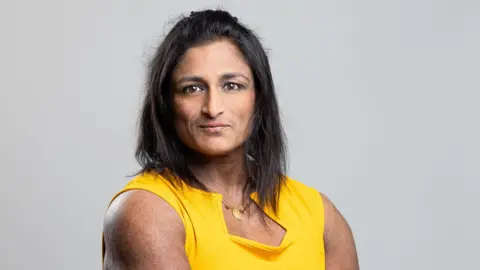 Hertfordshire County Council Ajanta Hilton with long dark hair smiling at the camera while wearing a yellow T-shirt